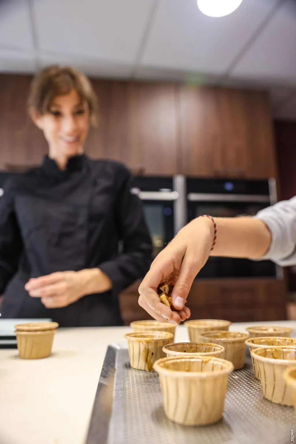 Nadia Jules garnissant des pâtisseries avec un participant